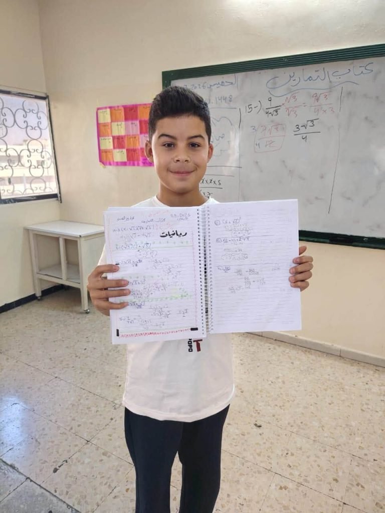 طالب يعرض دفتر الرياضيات